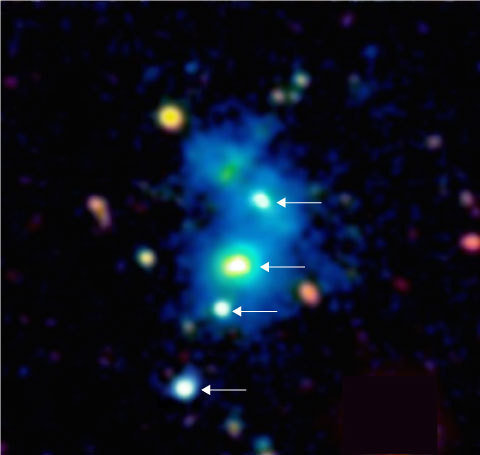 Image of the region of the space occupied by the rare quasar quartet. The four quasars are indicated by arrows. The quasars are embedded in a giant nebula of cool dense gas visible in the image as a blue haze. The nebula has an extent of one million light-years across, and these objects are so distant that their light has taken nearly 10 billion years to reach telescopes on Earth. This false color image is based on observations with the Keck 10m telescope on the summit of Maunakea in Hawaii.