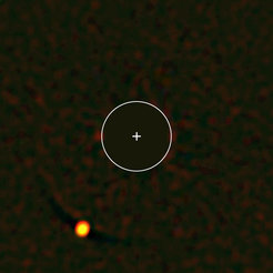 Abbildung des Planeten HIP 65426b (links unten), aufgenommen mit dem SPHERE-Instrument. SPHERE blendet dabei das Licht des Zentralsterns in der Bildmitte aus (blockierter Bereich = eingezeichneter Kreis), so dass das deutlich schwächere Licht des Planeten sichtbar wird. Das vom Planeten empfangene Licht lässt Rückschlüsse auf dessen Eigenschaften zu – in diesem Falle beispielsweise auf das Vorhandensein von Wasserdampf und rötlichen Wolken.
