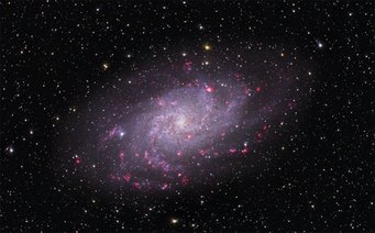 Abbildung 1: Bild des Dreiecksnebels M 33. Bei dieser Galaxie sehen die Astronomen direkt von oben auf die Scheibe mit ihren Spiralarmen. Die rosa Regionen enthalten neu geborene Sterne. Abbildung 1: Bild des Dreiecksnebels M 33. Bei dieser Galaxie sehen die Astronomen direkt von oben auf die Scheibe mit ihren Spiralarmen. Die rosa Regionen enthalten neu geborene Sterne.