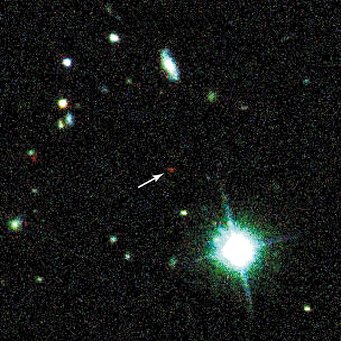 Abb. 1: Der entfernteste Quasar erscheint auf der Entdeckungsaufnahme als ein schwach leuchtendes, auffallend rotes Objekt (Pfeil) Abb. 1: Der entfernteste Quasar erscheint auf der Entdeckungsaufnahme als ein schwach leuchtendes, auffallend rotes Objekt (Pfeil)