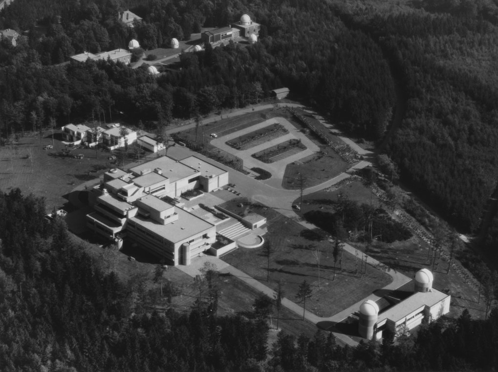 Das Max-Planck-Institut für Astronomie wurde in den Jahren 1971–1975 gebaut. Man erkennt von rechts unten nach links oben: Das Astrolabor, das Hauptgebäude, Direktoren- und Gästewohnhäuser, die Landessternwarte mit 6 Fernrohrkuppeln. © MPIA / Lossen