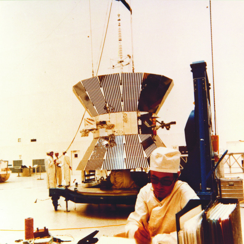 Bau der Sonnensonde HELIOS bei der Firma MBB in Ottobrunn. Die Außenseiten der großen „Garnrolle“ sind mit Sonnenzellen belegt. Dahinter sind im Schatten die Experimente angeordnet, darunter das Zodiakallicht-Instrument des MPIA. © MBB