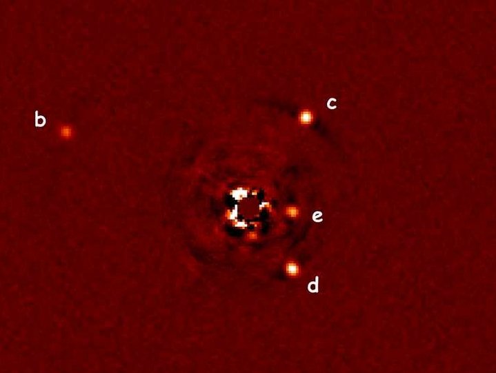 Seit kurzem sind Astronomen in der Lage, Exoplaneten nicht nur mit indirekten Methoden nachzuweisen, sondern auch auf Aufnahmen direkt sichtbar zu machen - wie hier am Beispiel des Planetensystems (b, c, d, e) um den Stern HR8799 (Mitte), der mithilfe einer Maske weitgehend ausgeblendet wurde. Die Aufnahme entstand mit dem Large Binocular Telescope (LBT), an dem das MPIA beteiligt ist.Im nächsten Schritt geht es darum, das Licht dieser Planeten spektral zu untersuchen, um z.B. die Zusammensetzung ihrer Atmosphären zu studieren. Wird man dort geeignete Bedingungen für mögliche Lebenformen finden?