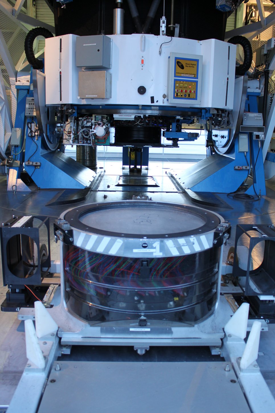 Die letzte Platte des SDSS-Plattenprogramms sitzt an der Basis des Sloan-Teleskops am Apache Point Observatorium in New Mexico, USA. Die farbigen Fasern, die unter der Platte sichtbar sind, wurden in ihre Löcher gesteckt und werden das Licht zu den Instrumenten transportieren.