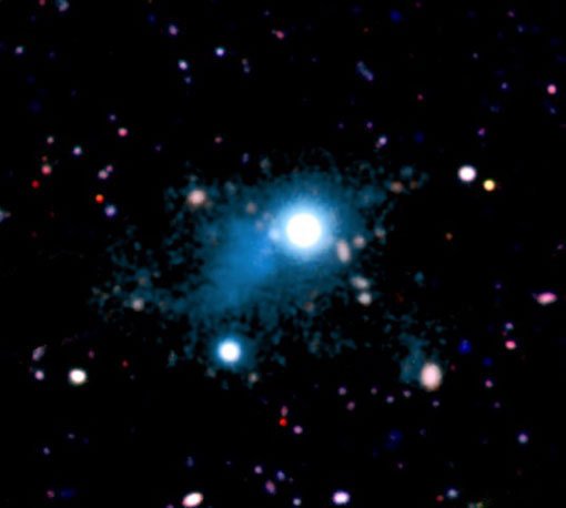 Abbildung 1: Der beobachtete Ausschnitt des kosmischen Netzwerks (türkisfarben) mit einer Ausdehung von rund 2 Millionen Lichtjahren, der in der direkten Umgebung des Quasars UM 287 (Bildmitte) beobachtet wurde. Das Gas leuchtet dank desselben Effekts, dem auch Leuchtstoffröhren ihr Licht verdanken. Dies ist das erste Bild eines Teils des kosmischen Netzwerks aus Gasfilamenten, das eine Schlüsselrolle für die Sternentstehung in Galaxien spielen dürfte.