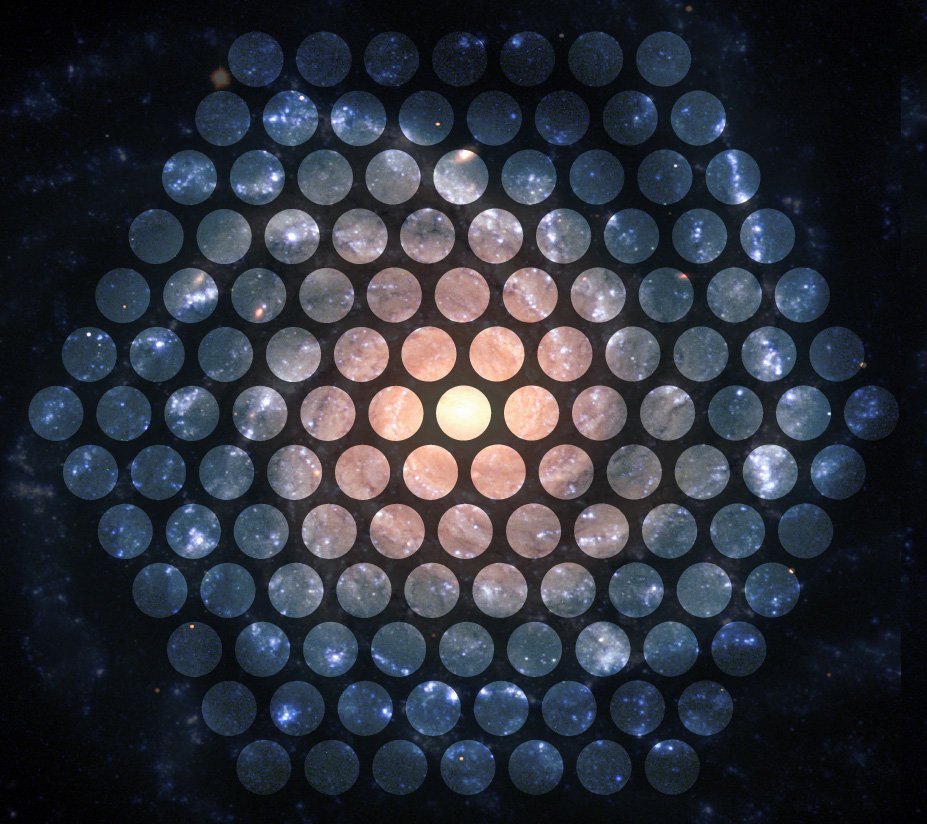 An image of a spiral galaxy with the face of a MaNGA 127 fiber integral field unit (IFU) superimpossed. Galaxies are being selected from the SDSS Main Galaxy Legacy Area, with selection cuts applied to only redshift and a color-based stellar mass estimate.