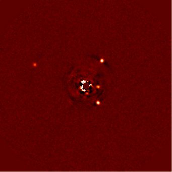Abb. 1: Direkte Abbildung des Planetensystems um HR8799. Links der Planet HR8799b, auf der rechten Seite, von oben nach unten, die Planeten c, e und d. Der Stern ist mithilfe einer Maske weitgehend ausgeblendet; Reste seines Lichts führen zu den Spuren in der Bildmitte. Abb. 1: Direkte Abbildung des Planetensystems um HR8799. Links der Planet HR8799b, auf der rechten Seite, von oben nach unten, die Planeten c, e und d. Der Stern ist mithilfe einer Maske weitgehend ausgeblendet; Reste seines Lichts führen zu den Spuren in der Bildmitte.