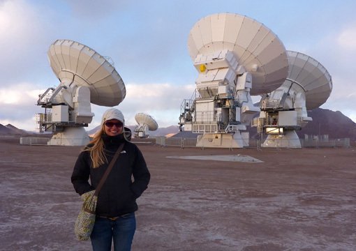 Abbildung 3: Jacqueline Hodge vom Max-Planck-Institut für Astronomie vor einigen der ALMA-Antennen während der Kommissionierungsphase des Teleskopverbunds im Frühjahr 2011, an der Hodge beteiligt war.