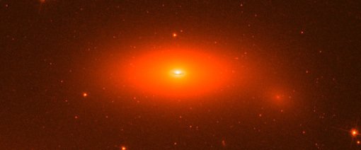 Abbildung 1: Aufnahme der Scheibengalaxie NGC 1277 mit dem Weltraumteleskop Hubble. Das Zentrum dieser kleinen, abgeflachten Galaxie enthält eines massereichsten Schwarzen Löcher, das jemals gefunden wurde. Mit 17 Milliarden Sonnenmassen ist das Schwarze Loch für beeindruckende 14% der Gesamtmasse der Galaxie verantwortlich.