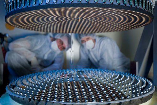 Abb. 1: Der bewegliche Sekundärspiegel während seiner Installation in den Laboren von Arcetri in Italien. Das Bild zeigt die 672 winzigen Magneten, die auf der Rückseite des Spiegels verteilt sind und die durch ein elektromechanisches Gerät gesteuert werden. Damit wird der Sekundärspiegel im zeitlichen Abstand von nur einer Tausendstel Sekunde so verformt, dass er Bildfehler erzeugt, die den Störungen durch die Atmosphäre genau entgegengesetzt sind und diese somit ausgleichen. Diese Korrektur in »Echtzeit« ist u.a. deshalb möglich, weil die Dicke des konkaven Sekundärspiegel bei einem Durchmesser von 91 cm nur 1,6 mm beträgt. Die Störungen der Atmosphäre werden zuvor präzise durch einen sogenannten Pyramiden-Sensor gemessen.