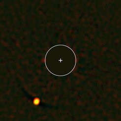 Abbildung des Planeten HIP 65426b (links unten), aufgenommen mit dem SPHERE-Instrument. SPHERE blendet dabei das Licht des Zentralsterns in der Bildmitte aus (blockierter Bereich = eingezeichneter Kreis), so dass das deutlich schwächere Licht des Planeten sichtbar wird. Das vom Planeten empfangene Licht lässt Rückschlüsse auf dessen Eigenschaften zu – in diesem Falle beispielsweise auf das Vorhandensein von Wasserdampf und rötlichen Wolken.