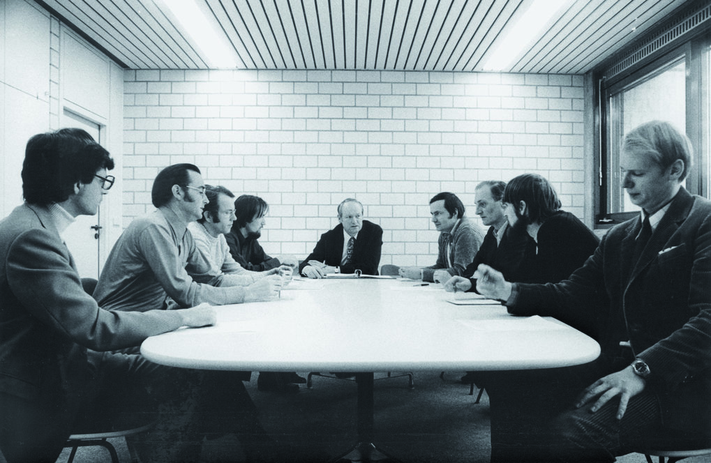 Institutsbesprechung im neuen Institut. Von links die Kollegen (mit ihren damaligen Aufgaben): Karl-Heinz Sorg (Verwaltungsleiter), Josef Solf (Spektroskopie, Bipolare Nebel), Thorsten Neckel (Gamsberg, OB-Sterne), Hans Hippelein (Fabry-Perot), Hans Elsässer (Direktor), Dietrich Lemke (THISBE, HII-Regionen), Klaus Bahner (Teleskope), Christoph Leinert (HELIOS, Zodiakallicht), Ronald Weinberger (Bipolare Nebel). © MPIA