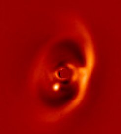 Nah-Infrarot-Aufnahme der Scheibe um den Stern PDS 70 (im Zentrum, ausgeblendet) aufgenommen mit dem SPHERE-Instrument am ESO-VLT. Der junge Exoplanet PDS 70b ist deutlich als hellste Punktquelle zu erkennen.