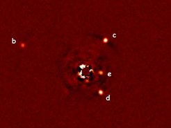Seit kurzem sind Astronomen in der Lage, Exoplaneten nicht nur mit indirekten Methoden nachzuweisen, sondern auch auf Aufnahmen direkt sichtbar zu machen - wie hier am Beispiel des Planetensystems (b, c, d, e) um den Stern HR8799 (Mitte), der mithilfe einer Maske weitgehend ausgeblendet wurde. Die Aufnahme entstand mit dem Large Binocular Telescope (LBT), an dem das MPIA beteiligt ist.Im nächsten Schritt geht es darum, das Licht dieser Planeten spektral zu untersuchen, um z.B. die Zusammensetzung ihrer Atmosphären zu studieren. Wird man dort geeignete Bedingungen für mögliche Lebenformen finden?