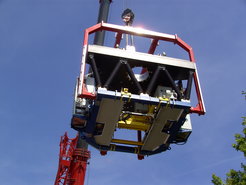 LINC-NIRVANA mounted in its traverse is lifted by a crane in a dizzy height.