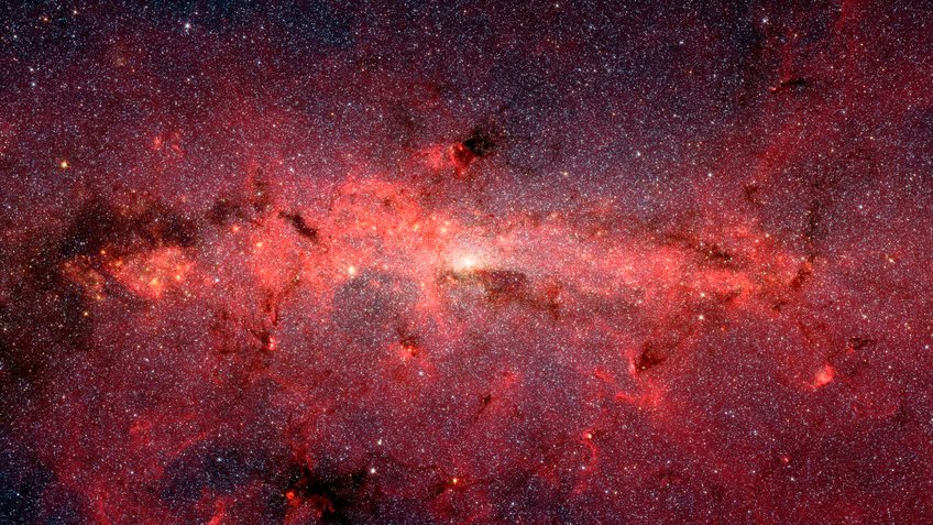 Zentralbereich der Milchstraße im Infrarotlicht. Das Spitzer Space Telescope der NASA hat mit diesem Bild die inneren 890 x 640 Lichtjahre der Milchstraße abgelichtet. Der Kernsternhaufen befindet sich in einem kleinen Bereich in der Nähe des zentralen massereichen schwarzen Lochs. Die ausgedehnten Strukturen im Bild sind weitestgehend Wolken aus Gas und Staub der Spiralarme der Milchstraße, die auf der Sichtlinie zwischen der Erde und des Galaktischen Zentrums liegen. Zentralbereich der Milchstraße im Infrarotlicht. Das Spitzer Space Telescope der NASA hat mit diesem Bild die inneren 890 x 640 Lichtjahre der Milchstraße abgelichtet. Der Kernsternhaufen befindet sich in einem kleinen Bereich in der Nähe des zentralen massereichen schwarzen Lochs. Die ausgedehnten Strukturen im Bild sind weitestgehend Wolken aus Gas und Staub der Spiralarme der Milchstraße, die auf der Sichtlinie zwischen der Erde und des Galaktischen Zentrums liegen.