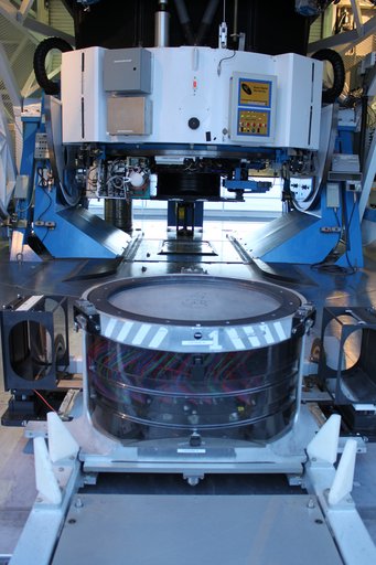 The final plate of the SDSS plate program sits at the base of the Sloan Telescope at the Apache Point Observatory in New Mexico, USA. The colored fibers visible below the plate have been plugged into their holes and will carry the light to the waiting instruments. The final plate of the SDSS plate program sits at the base of the Sloan Telescope at the Apache Point Observatory in New Mexico, USA. The colored fibers visible below the plate have been plugged into their holes and will carry the light to the waiting instruments.