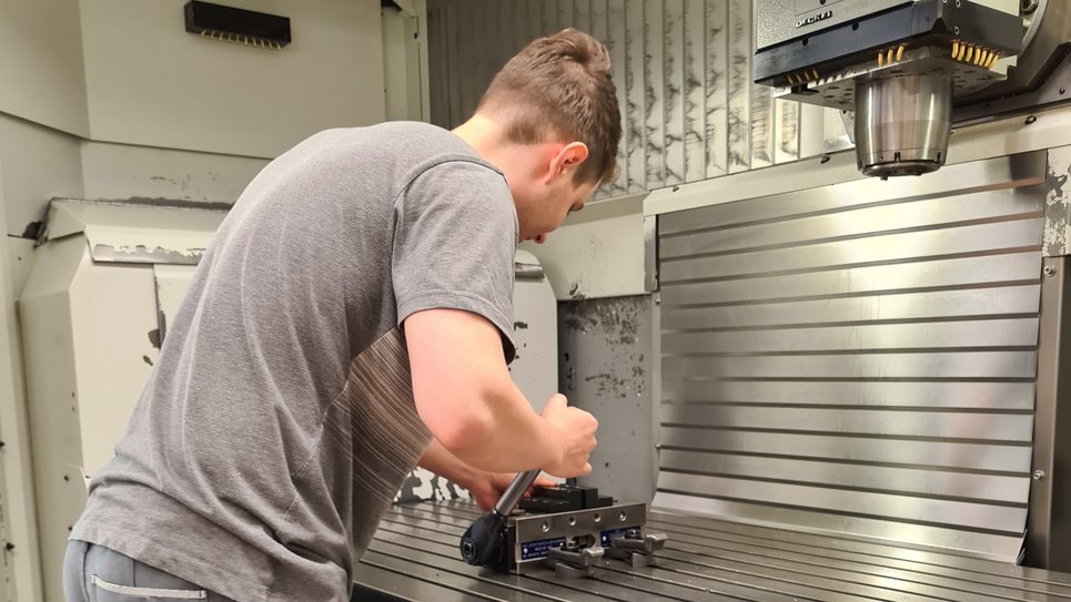 Der Techniker auf dem Foto bedient eine Maschine.Die Maschine schneidet und bohrt Metall.