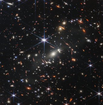 Blick in die Vergangenheit: Mehr als 13 Milliarden Jahre war das Licht unterwegs, das einige Galaxien auf diesem Foto ausgesendet haben. Zahlreiche farbige Punkte und länglich-ovale Objekte vor einem schwarzen Hintergrund.