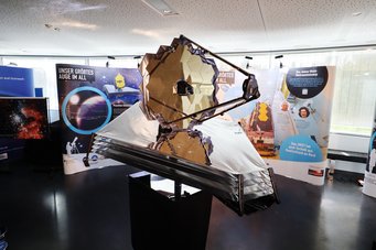 Modell des James Webb Weltraumteleskops im Maßstab 1:10, umgeben von einer Begleitausstellung zur Rolle des Max-Planck-Instituts für Astronomie bei der Entwicklung des Filterrads und zum Teleskop selbst. Ein interaktives Element erlaubt es, die Funktion eines solchen Filterrads selbst auszuprobieren. Modell des James Webb Weltraumteleskops im Maßstab 1:10, umgeben von einer Begleitausstellung zur Rolle des Max-Planck-Instituts für Astronomie bei der Entwicklung des Filterrads und zum Teleskop selbst. Ein interaktives Element erlaubt es, die Funktion eines solchen Filterrads selbst auszuprobieren.