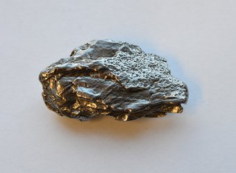 Ein kleines Fragment des Campo-del-Cielo-Eisenmeteoriten. Dieselbe intensive Hitze, die den Meteoriten teilweise aufgeschmolzen und so die hier sichtbare glatte Oberfläche erzeugt hat, hätte auch Eisen verdampft und abgetragen, wobei winzige, nanometergroße Partikel entstanden wären. Diese Partikel könnten als Katalysatoren für die Herstellung der chemischen Bausteine des Lebens auf der frühen Erde gedient haben. Ein kleines Fragment des Campo-del-Cielo-Eisenmeteoriten. Dieselbe intensive Hitze, die den Meteoriten teilweise aufgeschmolzen und so die hier sichtbare glatte Oberfläche erzeugt hat, hätte auch Eisen verdampft und abgetragen, wobei winzige, nanometergroße Partikel entstanden wären. Diese Partikel könnten als Katalysatoren für die Herstellung der chemischen Bausteine des Lebens auf der frühen Erde gedient haben.