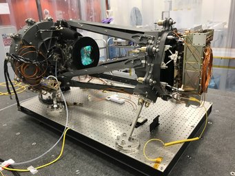 Die Esa-Mission Euclid im Reinraum des Laboratoire d'Astrophysique de Marseille. Das vollständig montierte NISP-Detektorsystem befindet sich auf der rechten Seite im Fokus des Teleskops. Klar erkennbar ist das blau schimmernde Linsensystem auf der linken Seite, wobei sich die Filter im Apparat hinter den Linsen befinden. Sie sorgen dafür, dass nur das Infrarotlicht aus dem einfallenden Licht herausgefiltert wird, bevor es auf das NISP-Instrument trifft. Gerippe eines Teleskops, fixiert auf einer Lochplatte in einem Labor