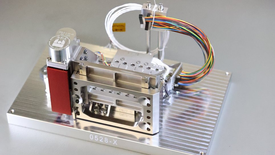 One of six completed flight model Precision Alignment Mechanisms (PAM), ready for delivery to JPL. MPIA was responsible for designing and constructing six flight and six additional engineering models. The red item in the foreground on the left protects the sensitive mechanism that moves the PAM from dust. This protective cover must be removed for space use before launch.