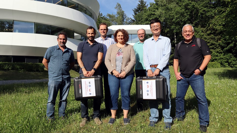 Handover of two of the six mechanisms for the CGI, an instrument for the Nancy Grace Roman Space Telescope, on 2 June 2022. From left to right: Doug Moore (JPL, PAM Assembly Lead), Oliver Krause (MPIA, PAM Project Lead), Guido Krein (von Hoerner &amp; Sulger, PAM Product Quality and Assurance Manager), Monica Ebert (MPIA, PAM Construction &amp; Assembly), Ulrich Klaas (PAM Deputy Manager &amp; Documentation), Fang Shi (JPL, CGI Active Optics Product Delivery Manager), Rigo Garcia (JPL, CGI Hardware Quality and Assurance Manager)