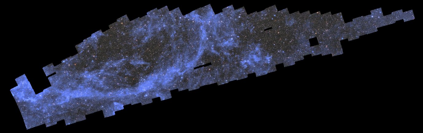 Ein breiter, länglicher schwarzer Hintergrund mit einem langen, bläulich gefleckten Feld aus Sternen, Galaxien und Wolkenfetzen in der oberen linken Diagonale des Bildes. Dieses fleckige Mosaik besteht aus mehreren fast quadratischen Fotografien, die in einer Form angeordnet sind, die an einen dünnen, verpixelten Wal erinnert, der in Richtung des unteren linken Bildrandes taucht. Die unzähligen funkelnden Galaxien und Sterne in diesem Mosaik drängen sich aneinander und erwecken den Eindruck eines dunkelgrauen Feldes mit häufigen Sprenkeln heller pastellgelber, roter und blauer Lichtpunkte in gleichmäßiger Verteilung. Ein Streifen silberblauer, diffuser Wolken in einer halb-elliptischen Form in der linken Bildhälfte und ein kleiner runder Fleck rechts von der Mitte stechen besonders hervor. An drei Stellen rechts der Bildmitte befinden sich kleine rechteckige Löcher im Mosaik. Der pechschwarze Hintergrund schimmert durch und steht in starkem Kontrast zu dem leuchtenden Bildfeld.