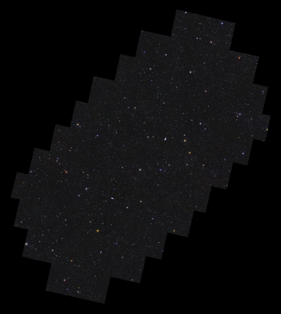 On a black background lies a rectangular shape with stepped edges all around, oriented with its long axis pointing from bottom left to top right. Contained within the shape are more than 11 million galaxies, and stars of various size, brightness and colour. Some galaxies are easily identifiable by their fuzzy elongated shapes. There is a hint of more densely populated regions of galaxies being organised into a web-like structure of filaments that permeates the image.
