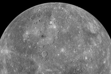 Ein teilweises Schwarz-Weiß-Mosaik des Planeten Merkur vor schwarzem Hintergrund, aufgenommen von der Raumsonde MESSENGER. Die graue, sphärische Oberfläche ist stark verkratert und von Einschlagstellen unterschiedlicher Größe gezeichnet, was auf Milliarden Jahre kosmischen Bombardements hindeutet. Das Oberflächenmaterial ist dunkel und basaltisch, mit markanten hellen Strahlenkratern, in denen frisches Material aus dem Untergrund ausgeworfen wurde. Da keine Atmosphäre die Sicht trübt, zeigt das Bild scharfe, kontrastreiche Strukturen, die eine Welt beschreiben, die direkt der Weltraumumgebung und der Sonnenstrahlung ausgesetzt ist.