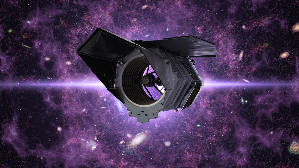 The Roman space telescope is positioned in the foreground against a backdrop of glowing purple nebulae and numerous galaxies. The telescope features a dark, angular structure with a large central mirror and several rectangular components. The scene conveys a sense of depth and vastness in space.